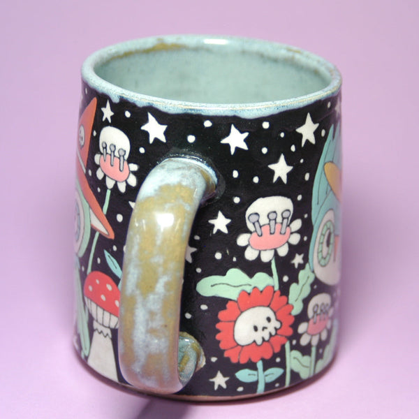 Ceramic mug with colorful designs on a pink background