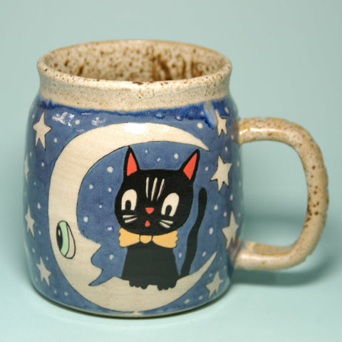 Ceramic mug with a black cat design on a blue background