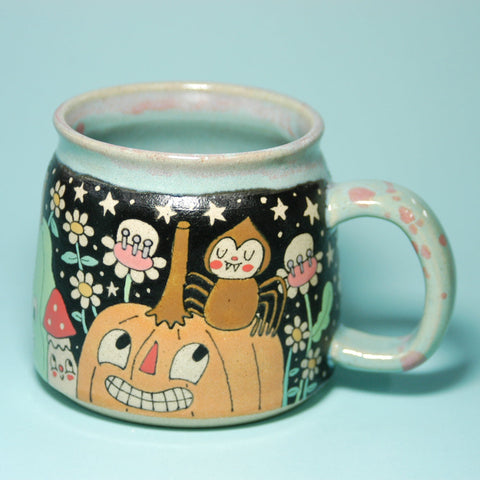 Ceramic mug with Halloween-themed design on a light blue background