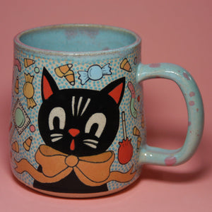 Ceramic mug with a black cat design on a pink background