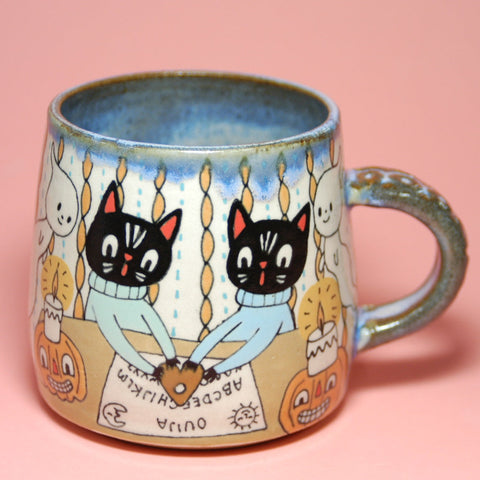 Mug with black cat ouija design on a pink background