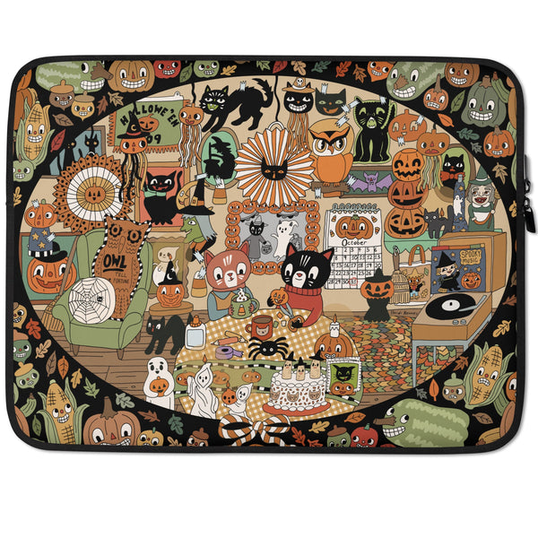  laptop sleeve covered in an illustration of two cats making halloween crafts in a decorated room.