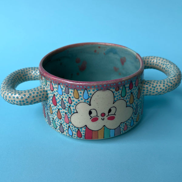 Ceramic bowl with cloud design and colorful raindrop pattern on a blue background