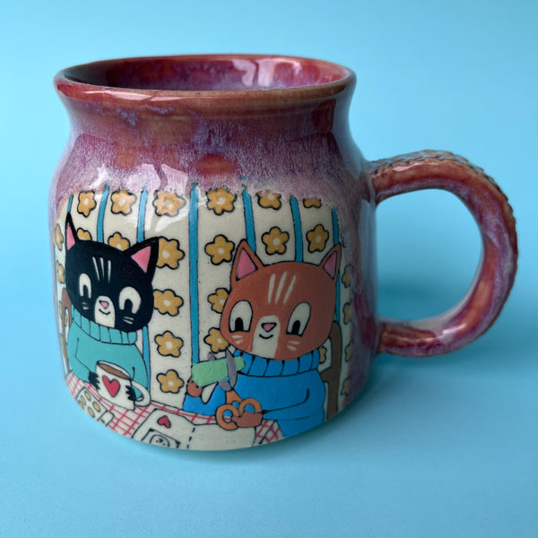 Ceramic mug with cartoon cats design on a blue background