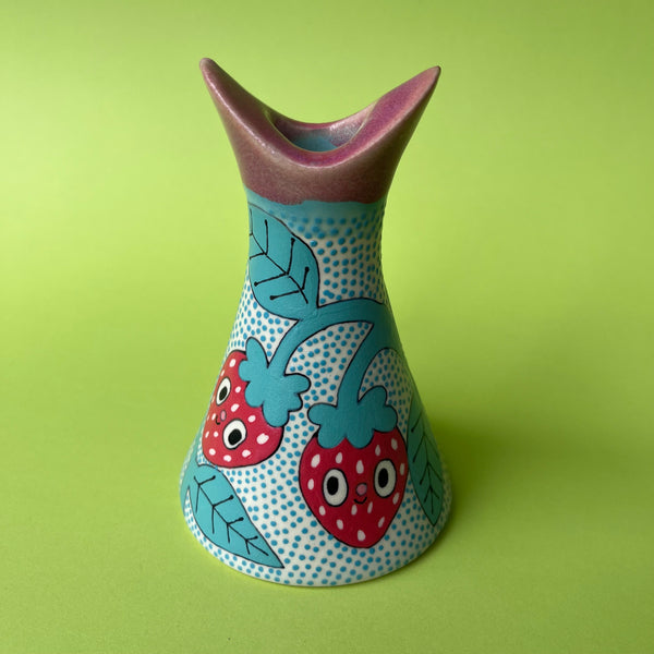 Decorative candle holder with strawberry design on a green background