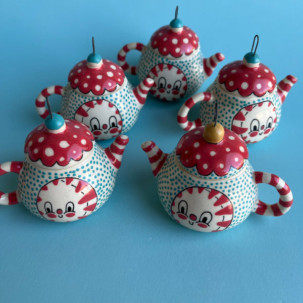 decorative teapot ornaments with polka dot patterns on a blue background