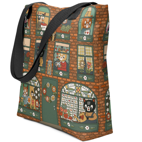 A tote bag that looks like a brick apartment building with cats doing various activities in the windows.