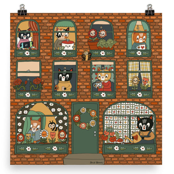 A print of a brick apartment building with cats doing different activities. 