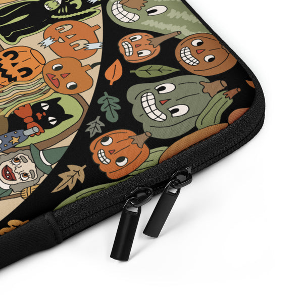Close-up of a zippered fabric sleeve or pouch with a Halloween-themed print featuring cartoon pumpkins, a black cat, and autumn leaves on a black background, shown on a white studio background.