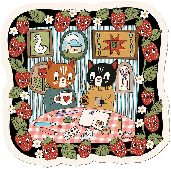 Illustration of two cats at a table with craft supplies, surrounded by strawberries and flowers.