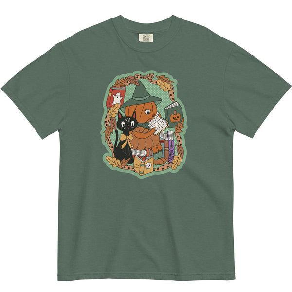 pumpkin headed girl reading with a pet cat on a green t-shirt.